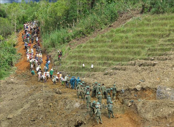 Người dân cùng các cán bộ, chiến sĩ Quân đoàn 34 triển khai công tác mở đường vào 5 thôn ở xã Ngọc Linh (Quảng Ngãi) bị cô lập do mưa lũ. Ảnh: Dư Toán – TTXVN