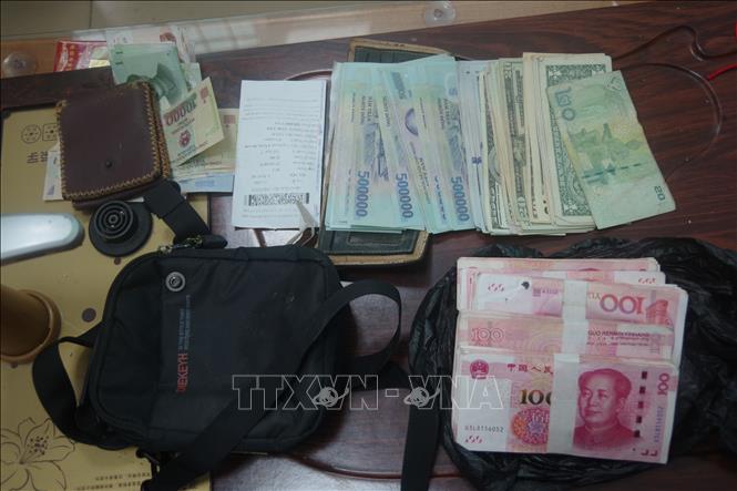 Tiền Việt Nam, tiền Trung Quốc, tiền đô la Mỹ được lực lượng BĐBP thu giữ tại cửa khẩu của đối tượng Ngô Tân Kích. Ảnh: TTXVN phát 