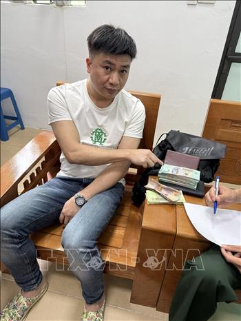 Đối tượng Bàn Khai Minh vận chuyển gần 200 triệu Việt Nam đồng từ Việt Nam sang Trung Quốc bị BĐBP bắt giữ. Ảnh: TTXVN phát
