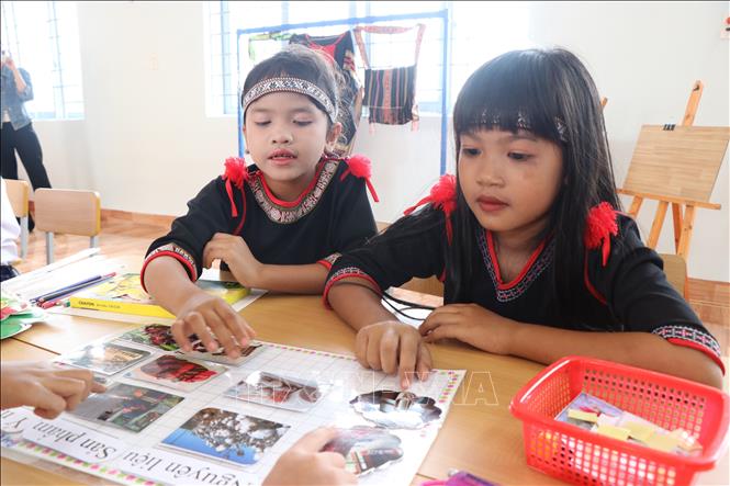 Học sinh thích thú khi được tự tay trải nghiệm sáng tạo cùng thổ cẩm. Ảnh: Nguyên Dung – TTXVN