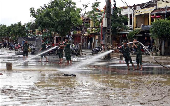 Lực lượng quân đội tham gia làm sạch môi trường phố cổ Hội An sau lũ. Ảnh: Trần Tĩnh -TTXVN