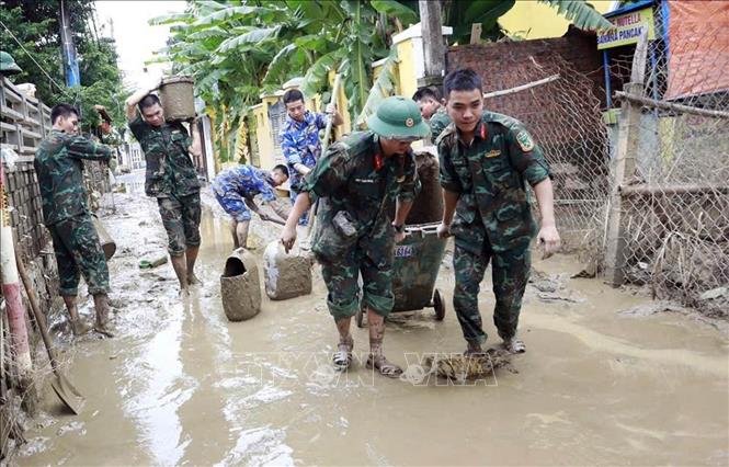 Lực lượng quân đội tham gia làm sạch môi trường phố cổ Hội An sau lũ. Ảnh: Trần Tĩnh -TTXVN