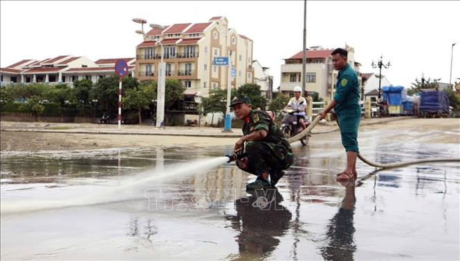 Lực lượng quân đội tham gia làm sạch môi trường phố cổ Hội An sau lũ. Ảnh: Trần Tĩnh -TTXVN