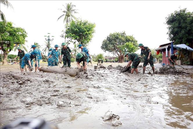 Lực lượng quân đội tham gia làm sạch môi trường phố cổ Hội An sau lũ. Ảnh: Trần Tĩnh -TTXVN