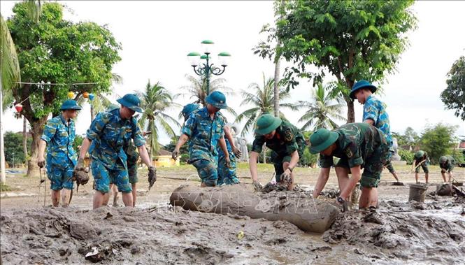 Lực lượng quân đội tham gia làm sạch môi trường phố cổ Hội An sau lũ. Ảnh: Trần Tĩnh -TTXVN