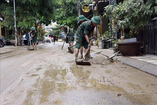 Lực lượng quân đội tham gia làm sạch môi trường phố cổ Hội An sau lũ. Ảnh: Trần Tĩnh -TTXVN