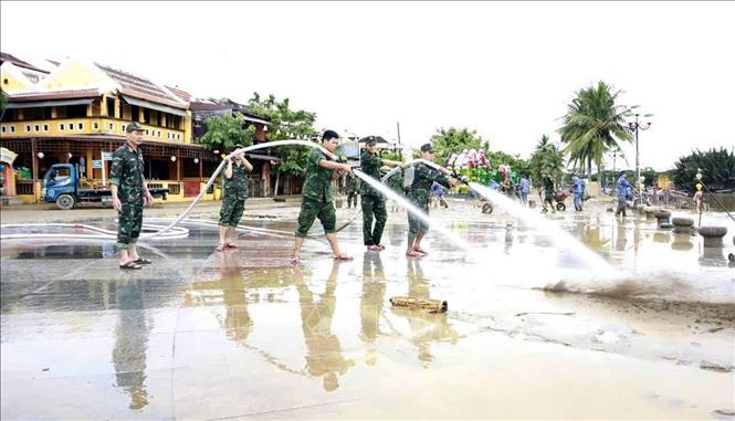 Lực lượng quân đội tham gia làm sạch môi trường phố cổ Hội An sau lũ. Ảnh: Trần Tĩnh -TTXVN