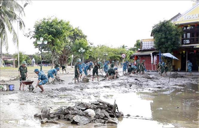 Lực lượng quân đội tham gia làm sạch môi trường phố cổ Hội An sau lũ. Ảnh: Trần Tĩnh -TTXVN