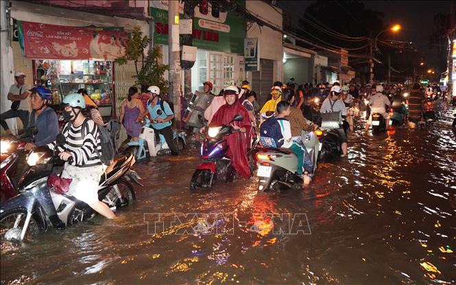Người dân chật vật dắt bộ trên một con đường tại phường Bình Quới, TP. Hồ Chí Minh. Ảnh:  Trung Tuyến - TTXVN