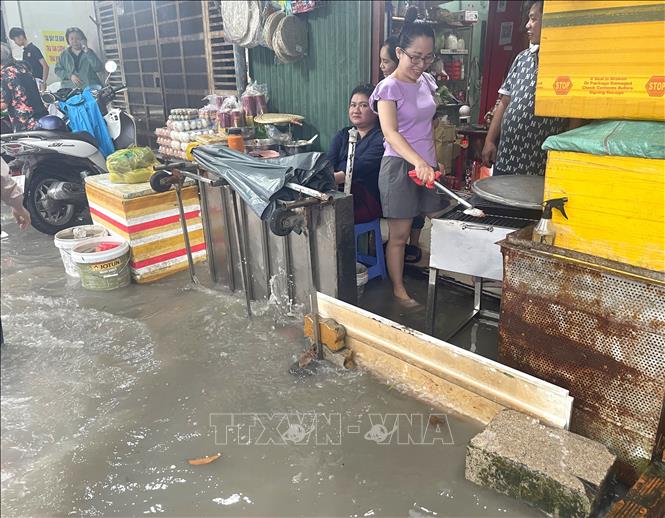 Người dân dùng đủ mọi cách chắn sóng nước tràn vào nhà trên địa bàn phường Tân Mỹ, TP. Hồ Chí Minh. Ảnh: Hương Giang – TTXVN  