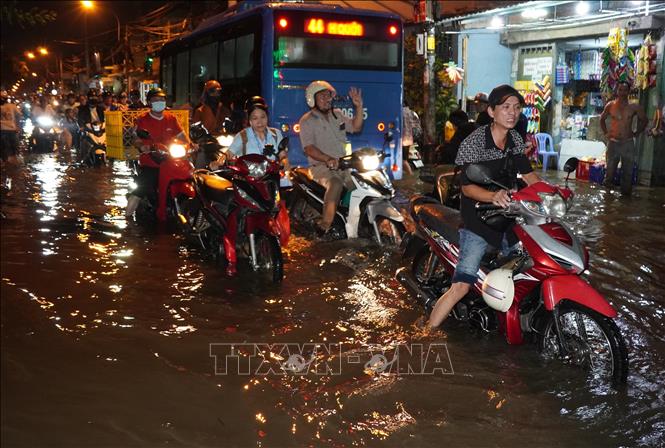 Người dân ngao ngán dắt bộ về nhà vì xe chết máy trên đường Bình Quới, TP. Hồ Chí Minh. Ảnh: Trung Tuyến  - TTXVN 