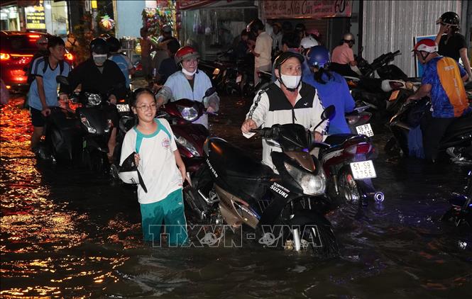 Dù được điều chỉnh giờ tan học, nhưng nhiều học sinh vật bị kẹt trong biển nước để về nhà. Ảnh: Hương Giang – TTXVN 