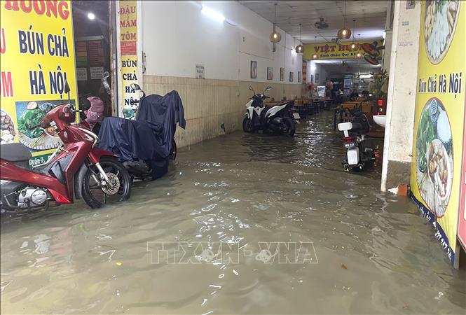 Một quán ăn trên địa bàn phường Tân Mỹ, TP. Hồ Chí Minh vắng khách vì nước ngập, tràn vào trong nhà. Ảnh: Hương Giang – TTXVN 