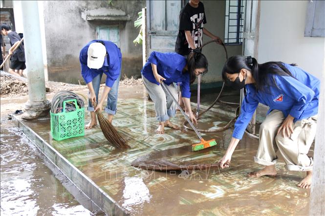 Thanh niên, tình nguyện viên hỗ trợ người dân thôn 2, xã Tuy Phong (Lâm Đồng) cào xúc bùn đất, vệ sinh nhà cửa. Ảnh: Nguyễn Thanh - TTXVN 