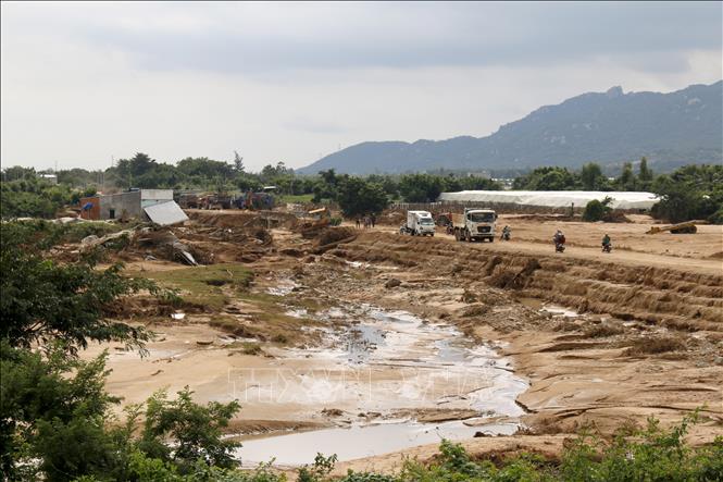 Huy động xe cơ giới hỗ trợ đối với những khu vực ngập sâu trong bùn đất do vỡ hồ chứa tại xã Tuy Phong. Ảnh: Nguyễn Thanh - TTXVN 