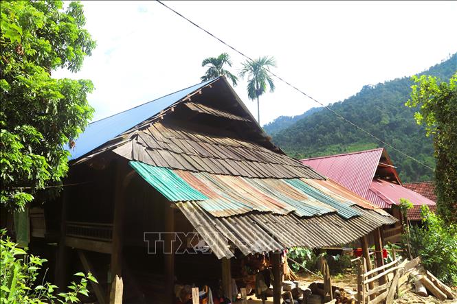 Ngôi nhà sàn cổ giữa đại ngàn Pù Huống được lợp mái bằng tôn xem lẫn những tấm gỗ sa-mu, pơ-mu còn sót lại. Ảnh: Xuân Tiến - TTXVN 