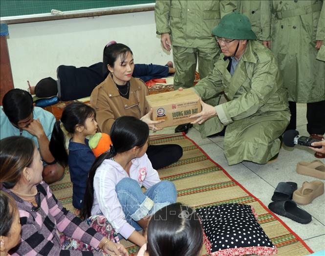 Chairman of Quang Ngai Provincial People's Committee Nguyen Hoang Giang visits and presents gifts at the gathering point for people avoiding Typhoon Kalmaegi at Duc Loi Primary and Secondary School. VNA Photo: Cao Nguyên