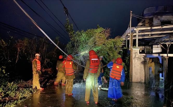 Lực lượng Công an xử lý các điểm cây xanh ngã đổ sau bão. Ảnh: TTXVN phát