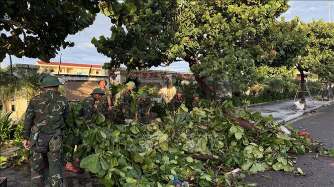 Cán bộ, chiến sỹ hỗ trợ người dân khắc phục hậu quả thiên tai. Ảnh Tường Quân- TTXVN