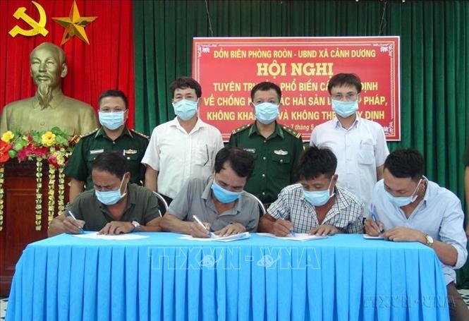 Ký cam kết giữa Đồn Biên phòng Roòn, UBND xã Cảnh Dương và các hộ ngư dân Quảng Bình về “Khai thác hải sản bất hợp pháp, không khai báo và không theo quy định” (IUU). Ảnh: Đức Thọ - TTXVN