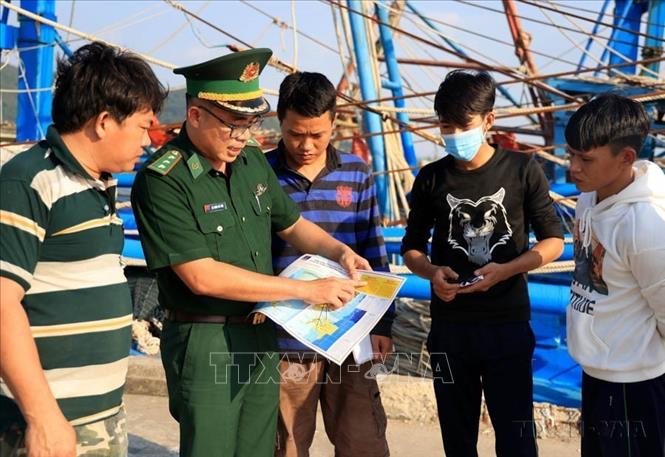Cán bộ biên phòng Trạm Kiểm soát Biên phòng Pháo Đài (Đồn Biên phòng Cửa khẩu Quốc tế Hà Tiên, BĐBP Kiên Giang) tuyên truyền cho ngư dân về các quy định phòng, chống vi phạm IUU. Ảnh: Hồng Đạt - TTXVN