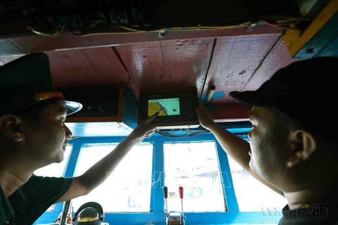 Bộ đội Biên phòng kiểm tra thiết bị giám sát hành trình khai thác thuỷ sản trên tàu cá trước khi ra khơi tại cảng cá huyện Hoài Nhơn, tỉnh Bình Định (2024). Ảnh: Vũ Sinh - TTXVN