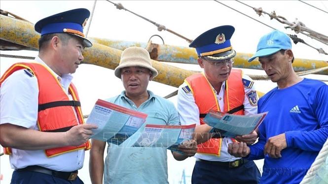 Lực lượng chức năng tuyên truyền về IUU cho ngư dân xã Long Hải, TP. Hồ Chí Minh trước khi ra khơi đánh bắt hải sản. Ảnh: Hoàng Nhị - TTXVN.