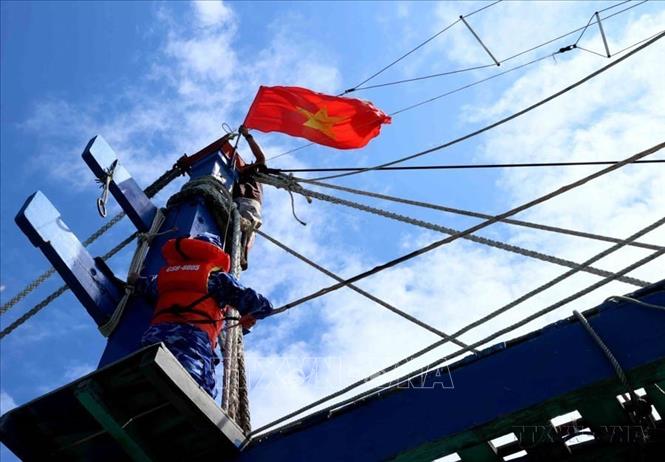 Cảnh sát biển Việt Nam tặng cờ tổ quốc cho ngư dân trên khu vực biển quanh quần đảo Thổ Chu (tỉnh Kiên Giang). Ảnh: An Đăng - TTXVN