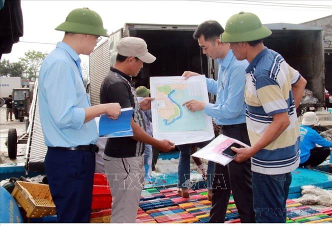 Trao tặng bản đồ cho ngư dân Nam Định trước khi ra khơi. Ảnh: Nguyễn Lành - TTXVN