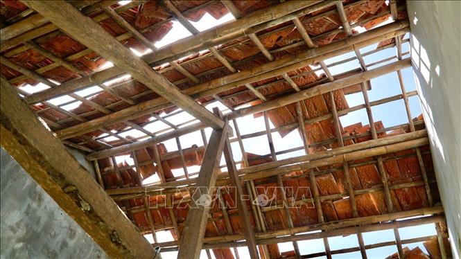 Gió giật mạnh làm hư hỏng mái nhà của người dân làng chài dưới chân cầu Đề Gi. Ảnh: Sỹ Thắng - TTXVN