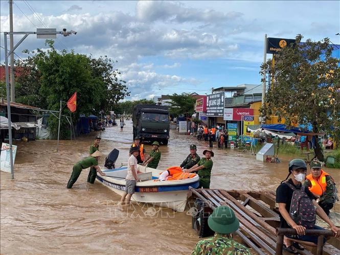 Lực lượng chức năng giúp dân di dời tài sản. Ảnh: TTXVN phát