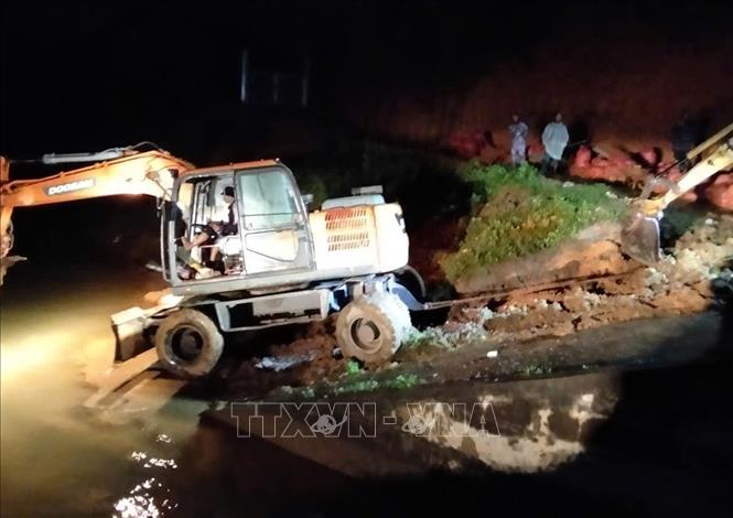 Phương tiện cơ giới được huy động đến để triển khai biện pháp gia cố thân đập hồ Cay An trong đêm 7/11. Ảnh: TTXVN phát
