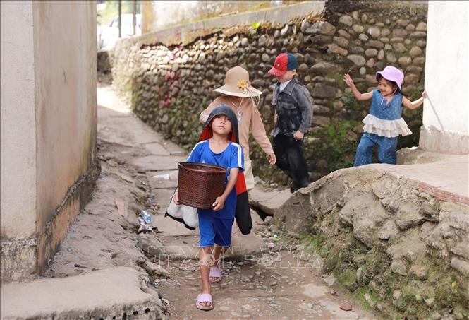 Càng về trưa và chiều, không khí bản làng càng nhộn nhịp khi con cháu đi dâng lễ chúc Tết ông bà, anh em họ hàng. Ảnh: Quý Trung – TTXVN