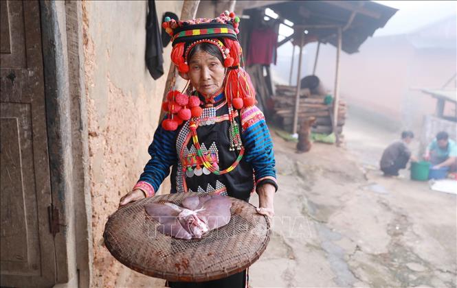 Sau khi mổ lợn xong, chủ nhà đưa lá gan vào trong nhà để làm lý trước khi xem. Ảnh: Quý Trung – TTXVN