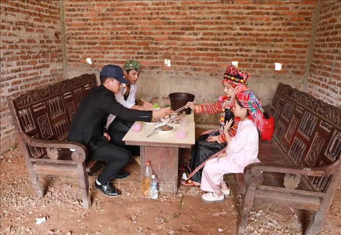 Ít hay nhiều, mọi người đều ngồi vào mâm, ăn những món ăn để thể hiện lòng thành kính và lấy may mắn cho một năm mới. Ảnh: Quý Trung – TTXVN