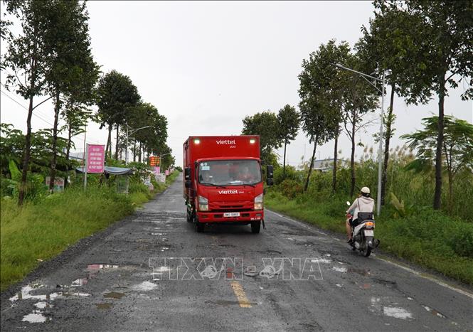Để né tránh ổ gà, ổ voi, nhiều tài xế phải lấn sang phần đường dành cho các phương tiện đi chiều ngược lại. Ảnh: Văn Sĩ - TTXVN                                