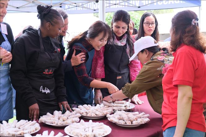 Các thành viên thích thú với sản phẩm nem chay rán do chính tay mình làm từ sơ chế đến cuốn nem. Ảnh: Hồng Minh - PV TTXVN tại Nam Phi