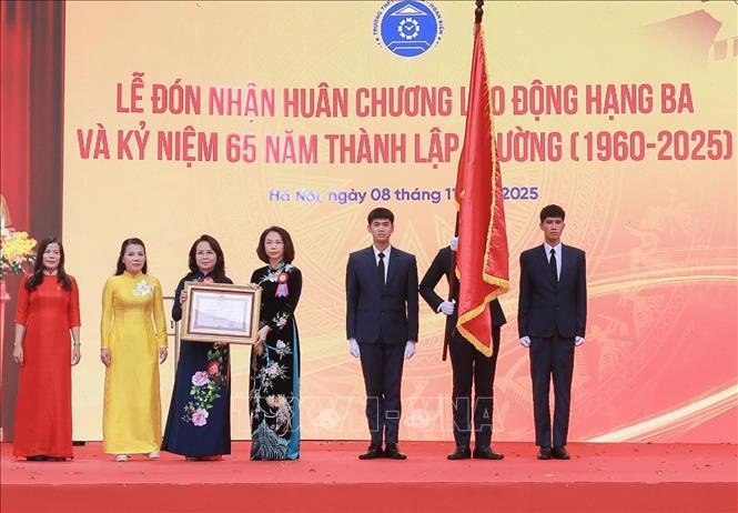 Bà Vũ Thu Hà, Thành ủy viên, Phó Chủ tịch UBND thành phố Hà Nội trao Huân chương Lao động hạng Ba của Chủ tịch nước cho Ban lãnh đạo nhà trường. Ảnh: Phan Phương-TTXVN