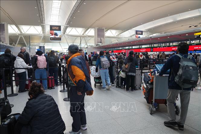 Hành khách chờ đợi tại khu vực làm thủ tục ở sân bay John F. Kennedy, New York, Mỹ. Ảnh: THX/TTXVN
