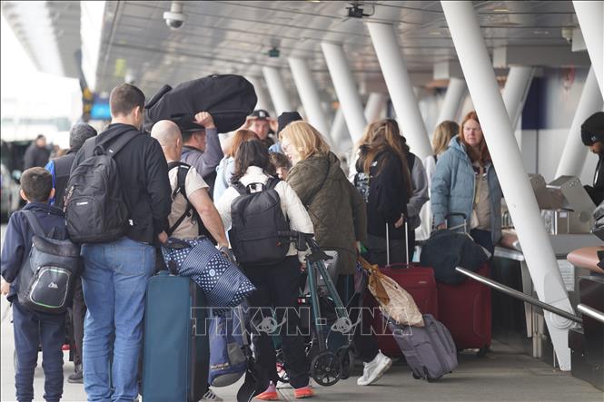Hành khách chờ đợi tại khu vực làm thủ tục ở sân bay John F. Kennedy, New York, Mỹ. Ảnh: THX/TTXVN
