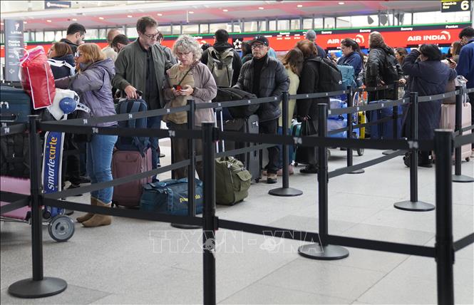 Hành khách chờ đợi tại khu vực làm thủ tục ở sân bay John F. Kennedy, New York, Mỹ. Ảnh: THX/TTXVN