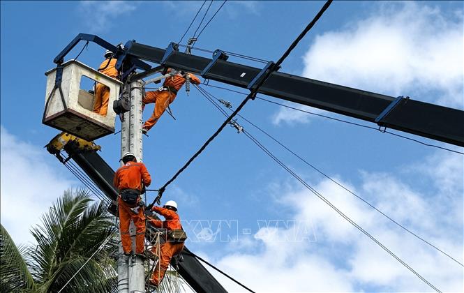 Công nhân ngành điện chạy đua thời gian, khôi phục điện cho khách hàng. Ảnh: Tường Quân - TTXVN