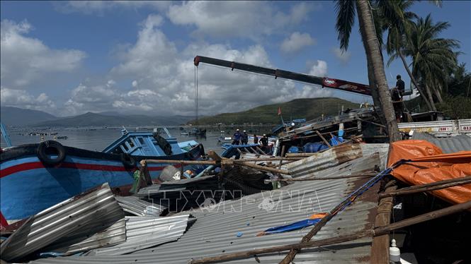 Người dân dùng cẩu khắc phục tàu thuyền hư hỏng. Ảnh: Tường Quân - TTXVN