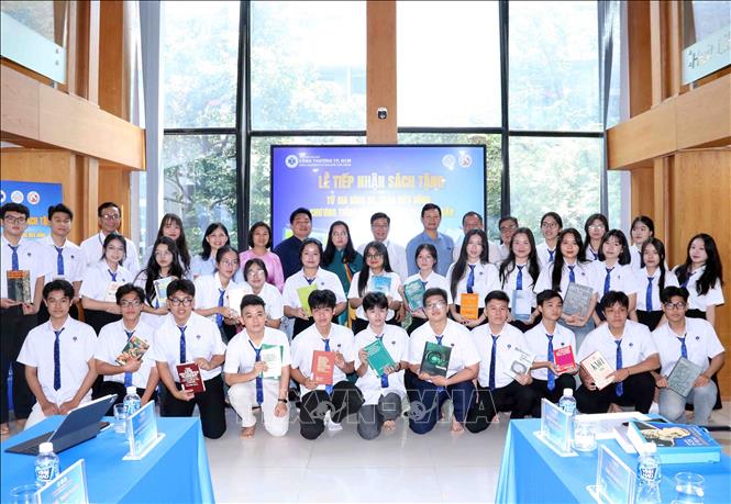 Bà Lê Thị Mỹ Châu, thay mặt Tiến sĩ Võ Tá Hân; ông Lê Nam Sơn, Chủ tịch Trường Sa Group, ông Lê Quốc Tuấn, Giám đốc chương trình Books4Vietnam chụp ảnh lưu niệm cùng thầy và trò Trường Đại học Công thương Thành phố Hồ Chí Minh. Ảnh: Xuân Khu-TTXVN