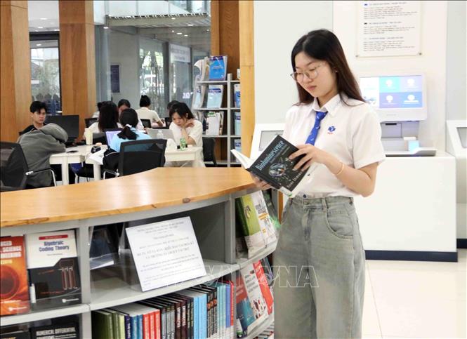 Sinh viên Đại học Công thương Thành phố Hồ Chí Minh xem những cuốn sách do Tiến sĩ Võ Tá Hân trao tặng. Ảnh: Xuân Khu-TTXVN
