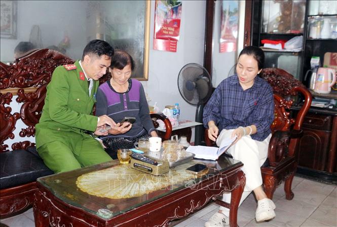 Công an phường Phủ Lý đến từng hộ tuyên truyền, hướng dẫn người dân tham gia góp ý dự thảo các văn kiện Đại hội XIV của Đảng thông qua ứng dụng VNeID. Ảnh: Nguyễn Chinh – TTXVN