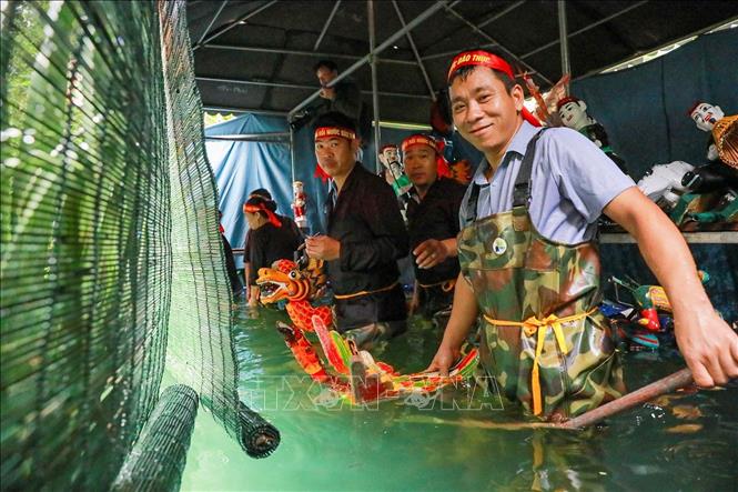 Các nghệ nhân đứng trong buồng trò (thủy đình) được che chắn kỹ lưỡng, sử dụng sào, dây và bộ máy điều khiển ẩn dưới mặt nước để làm cho con rối cử động, di chuyển một cách sống động như thật. Ảnh: Khánh Hoà - TTXVN