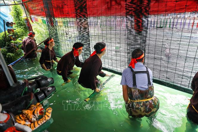 Các nghệ nhân đứng trong buồng trò (thủy đình) được che chắn kỹ lưỡng, sử dụng sào, dây và bộ máy điều khiển ẩn dưới mặt nước để làm cho con rối cử động, di chuyển một cách sống động như thật. Ảnh: Khánh Hoà - TTXVN