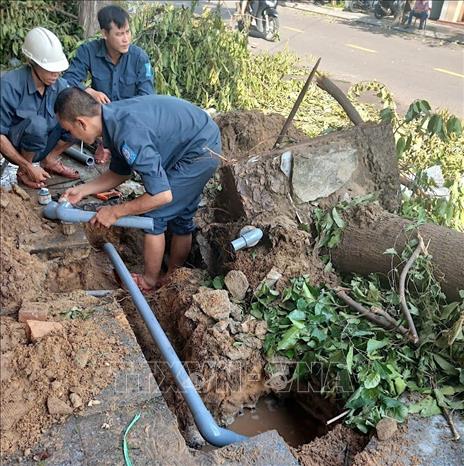 Công nhân Công ty Cấp thoát nước Bình Định khẩn trương sửa chữa đường ống nước bị hư hỏng do bão số 13. Ảnh: Quang Thái- TTXVN