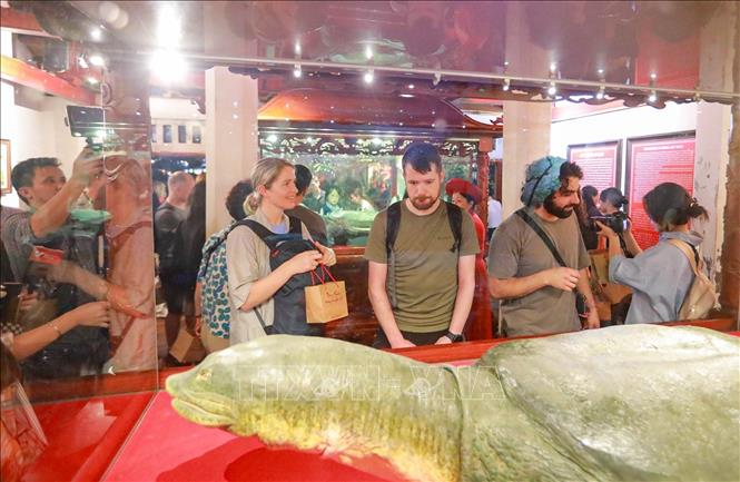 Du khách nước ngoài trải nghiệm Tour đêm “Ngọc Sơn – Đêm huyền bí”. Ảnh: Khánh Hoà - TTXVN